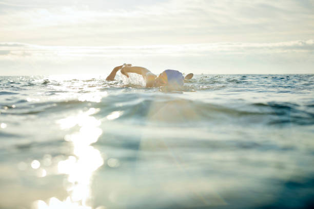 istock Determined mature swimmer swimming in sea 1127360509