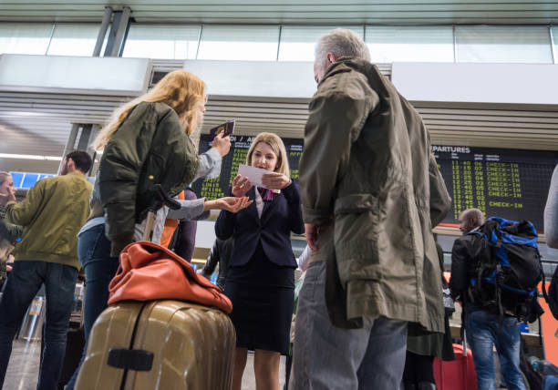 istock Airport Employee Helping Turists With Flights 1127360821