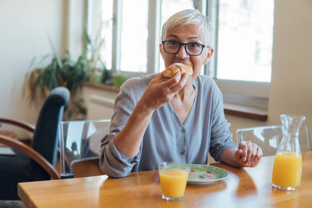 istock Woman taking a bite of croissant 1127360931