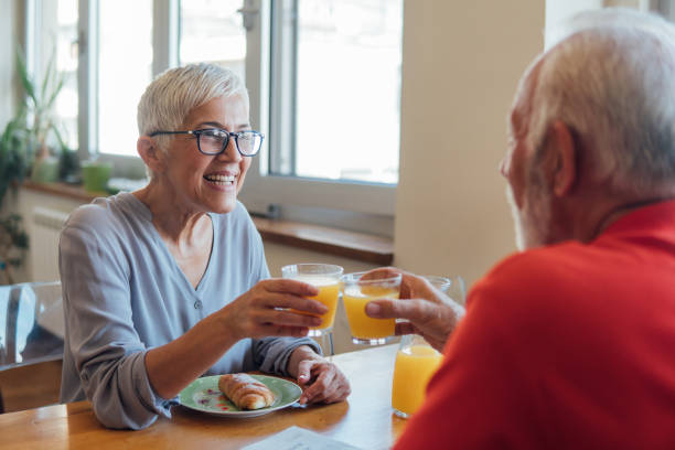 istock Senior couple drinking orange juice and smiling 1127361692
