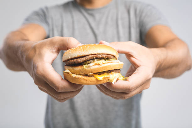 Young man holding a piece of hamburger