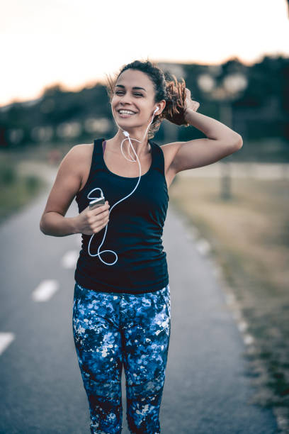 Cheerful Female Listening To Music While Taking a Walk stock photo