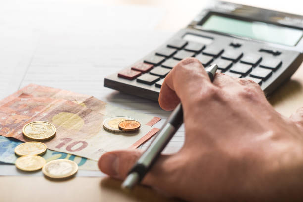 A calculator, coins and tax forms on the table to reckon