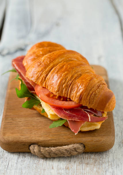 istock croissants with arugula, jamon, cheese and tomato on wooden surface 1127363853