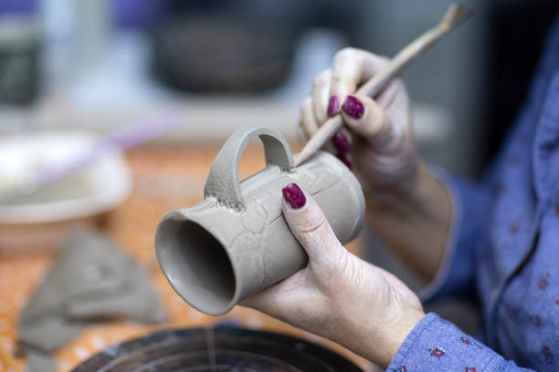 istock Hands of artist who make a mug from ceramic clay in studio 1127364109