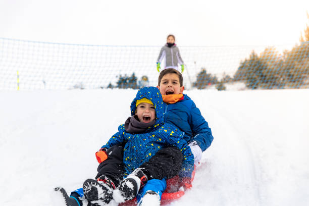istock Children playing with a sled on the snow 1127365672