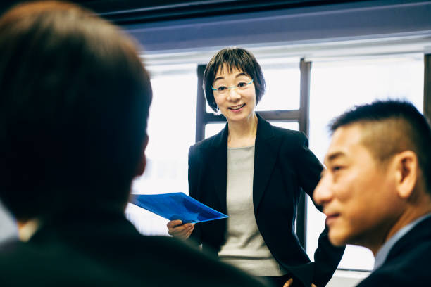 istock Female Chinese manager with file in meeting 1127372347