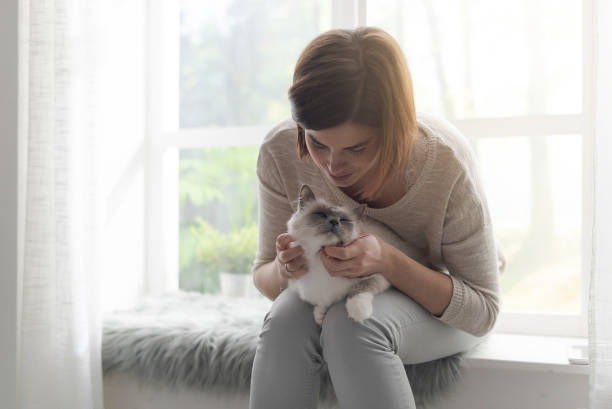 istock Woman hugging her cute cat at home 1127373547