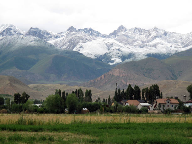 high in the mountains is the village several seasons of weather in a village called Bostyri, Issyk-Kul region горная гряда stock pictures, royalty-free photos & images