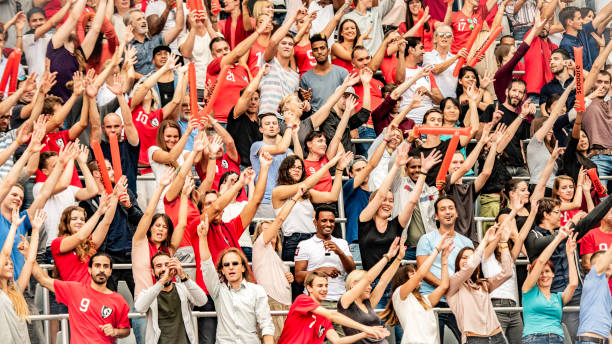 istock Crowd cheering for their team with arms raised 1127374655