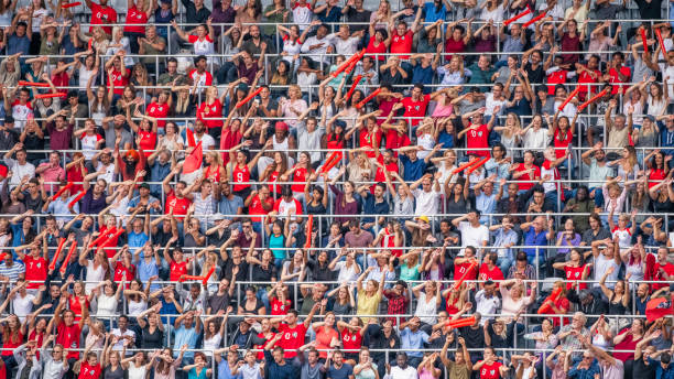 istock Crowd cheering for their team with arms raised 1127374660