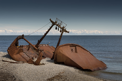 Old rusty wreck and rocky beach in Baltic Sea, natural environment. Osmussaar, Estonia, Europe.