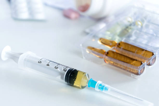 istock Medical syringe with injection solution, medicine pills and capsules on white background. Healthy medical concept 1127377892
