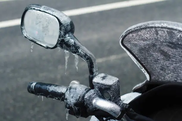 Photo of closeup of frozen motorcycle windshield and rear mirror
