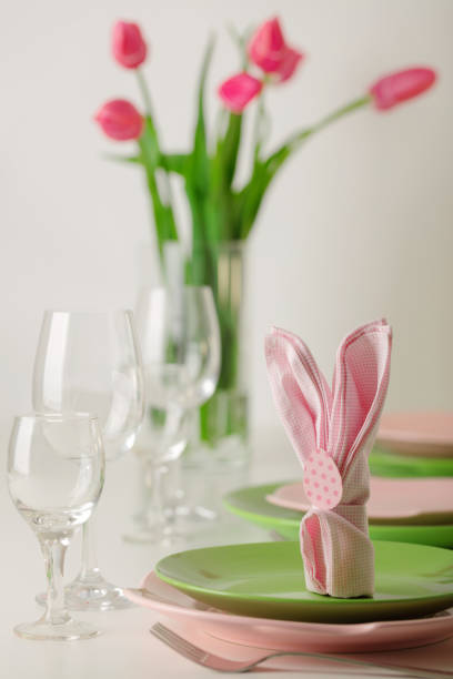 istock Happy easter. Decor and table setting of the Easter table is a vase with pink tulips and dishes of pink and green color. 1127380791