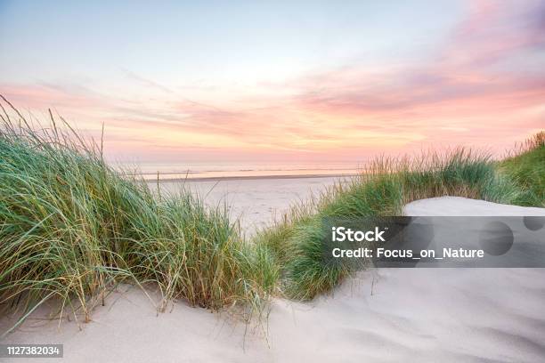 Sunset Over A Very Tranquil Beach Stock Photo - Download Image Now - Sand Dune, Beach, Grass