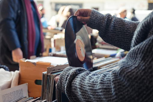 Customer browsing vybyl discs at a vintage flea market.