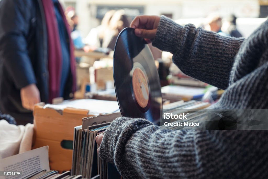 Old vinyl discs flea market Customer browsing vybyl discs at a vintage flea market. Record - Analog Audio Stock Photo