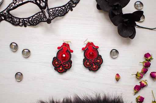 Beaded earrings/ Red garnet  soutache jewelry on the white wooden background. Women accessories