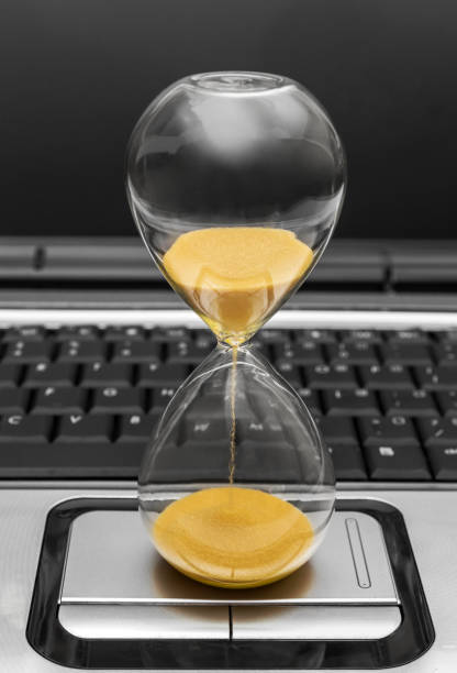 istock Hourglass on laptop keyboard. Close up. 1127384537