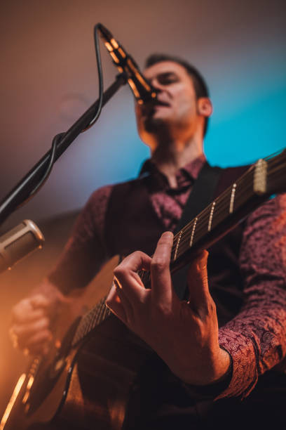 istock Rock musician singing and playing acoustic guitar 1127385889