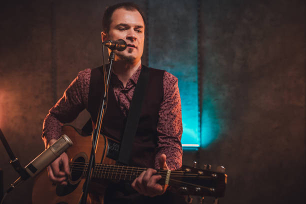 istock Musician singing and playing acoustic guitar 1127386298