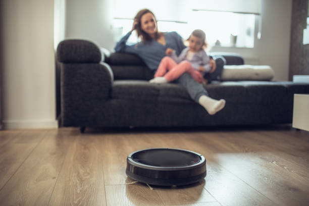 istock Robotic Vacuum Cleaner Cleaning While Mother and Daughter Relaxing 1127386351