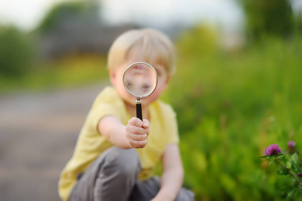 istock Little boy playing with magnifying glass. 1127388585