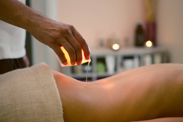 donna che si massaggia con una candela - head massage massaging beauty treatment massage therapist foto e immagini stock