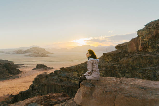 istock Woman looking at  Wadi Rum desert from rock 1127396637