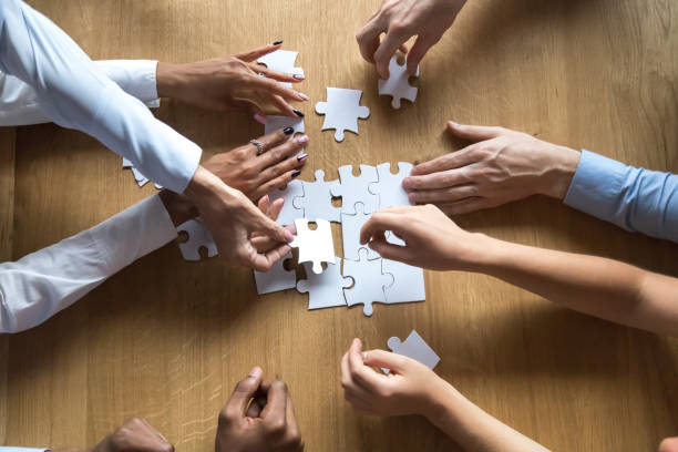 Above view people hands holding puzzle pieces