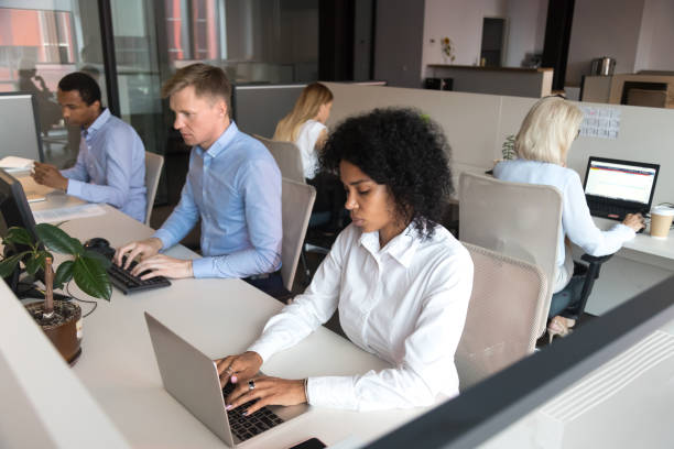 istock Diverse millennial employees sitting at desk working in coworking space 1127397440
