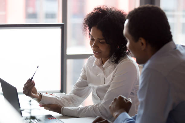 istock Black business partners sitting at desk looking at computer screen 1127397459