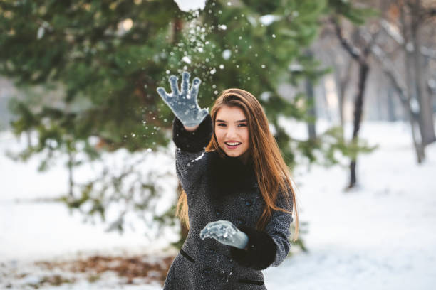 istock Beautiful woman throwing snowball 1127398900