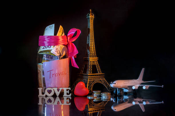 istock Savings for travelling with toy eiffel tower on dark background 1127399215