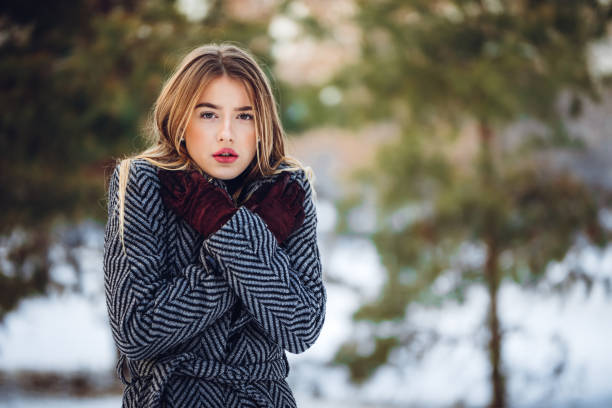 Portrait of a young woman shivering in the snow