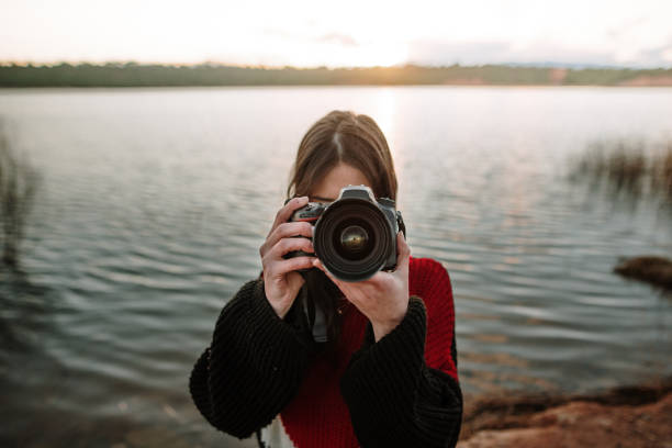 istock Young woman taking a picture with a DSLR camera 1127400719