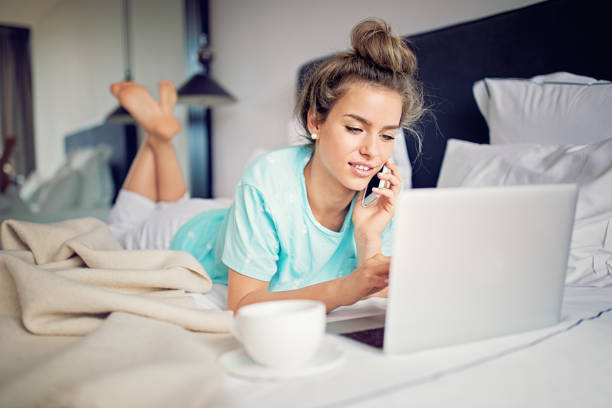 istock Beautiful young girl is talking and browsing using her laptop in the bed 1127400901