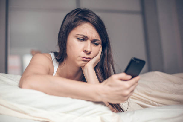 istock Sad woman reading message on the phone 1127401120