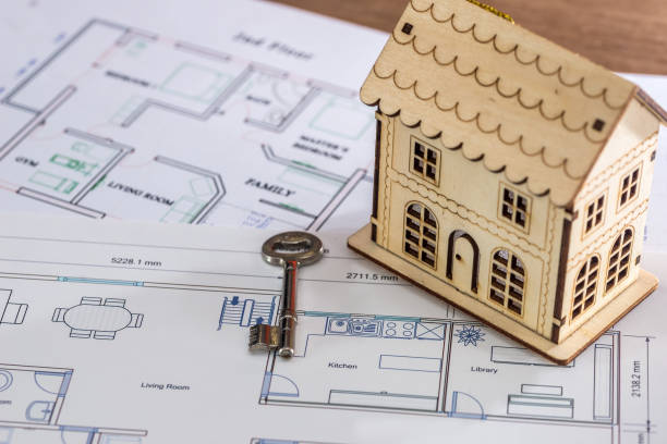istock Toy wooden house with key on architectural project 1127401923