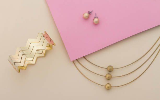 золотые украшения на розовом и бежевом фоне - earring gold jewelry contemporary стоковые фото и изображения