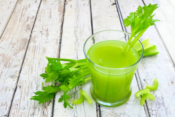 istock Celery juice in a glass over a rustic white wood background 1127402474