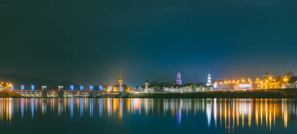 istock Illuminated Buildings By River Against Sky At Night 1127405486