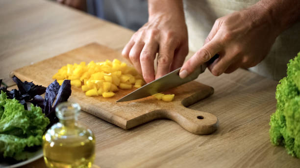 istock Senior man cutting fresh pepper on chopping board, preparing vegetarian salad 1127406229