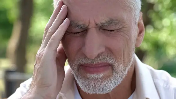 Mature man feeling sudden sharp pain in head, migraine attack, risk of thrombus