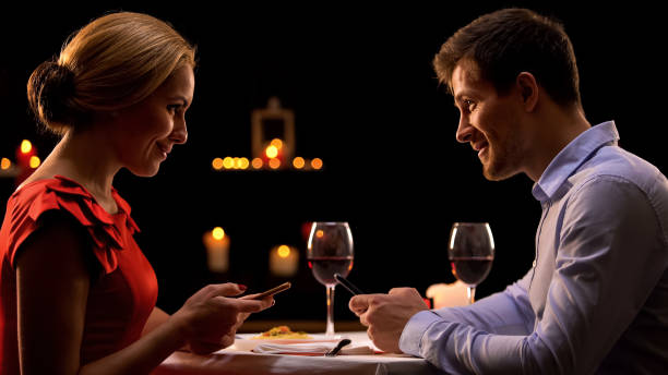 istock Couple in restaurant using smartphones, dating website concept, acquaintance 1127406736