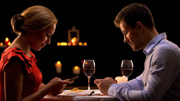 istock Addicted couple using smartphones, ignoring each other on romantic dinner 1127406737