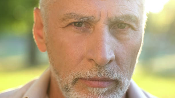 istock Bearded man in his 70s thinking about future and looking into camera, closeup 1127406918