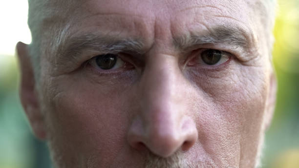 Old sad grandfather looking into camera, thinking about future, depression