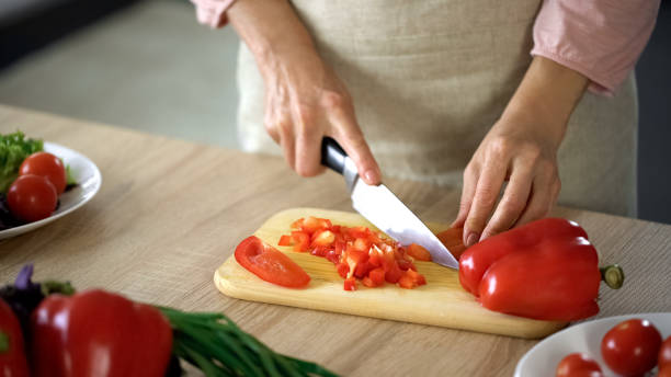 istock Female chef cutting fresh pepper on board kitchen, cooking salad, culinary show 1127409250